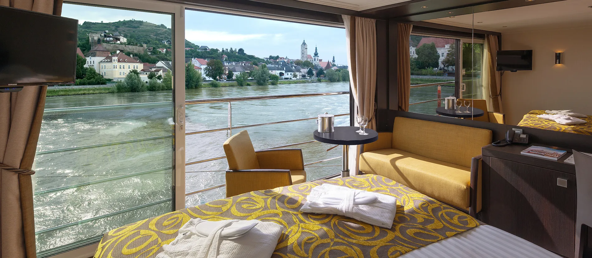 River cruise cabin with panoramic view of European town and waterfront