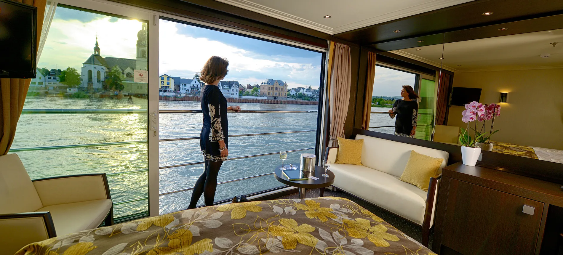 River cruise cabin with panoramic windows overlooking European waterfront town