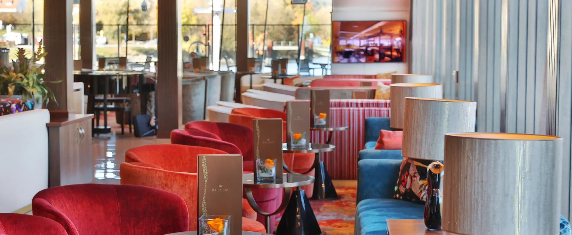 Colorful cafe interior with red chairs, blue sofas, and menu on table