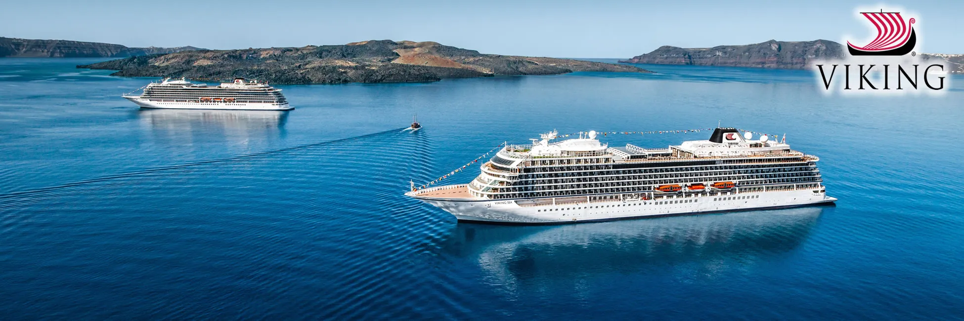 Viking cruise ships sailing near rocky islands in blue Mediterranean waters