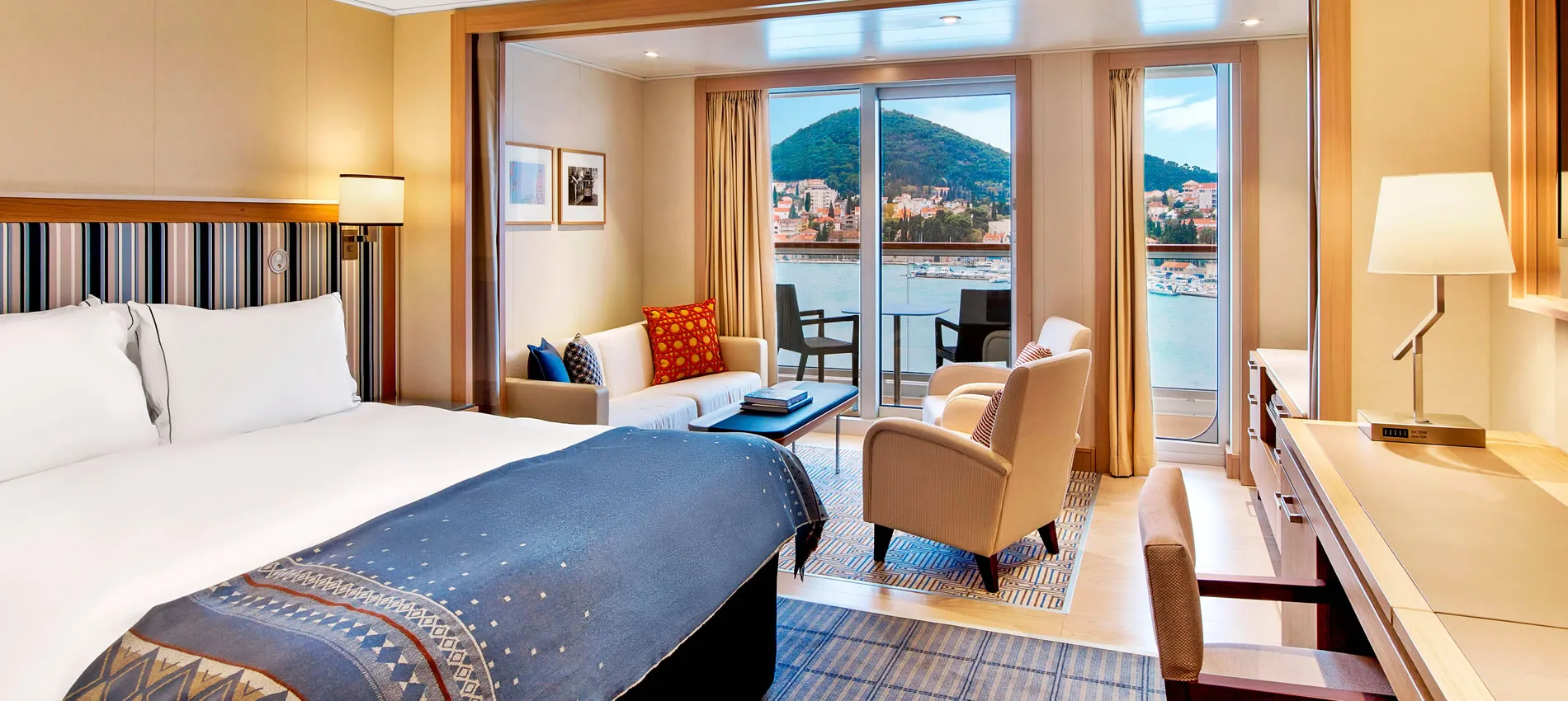 Luxury room with balcony overlooking coastal town and mountain