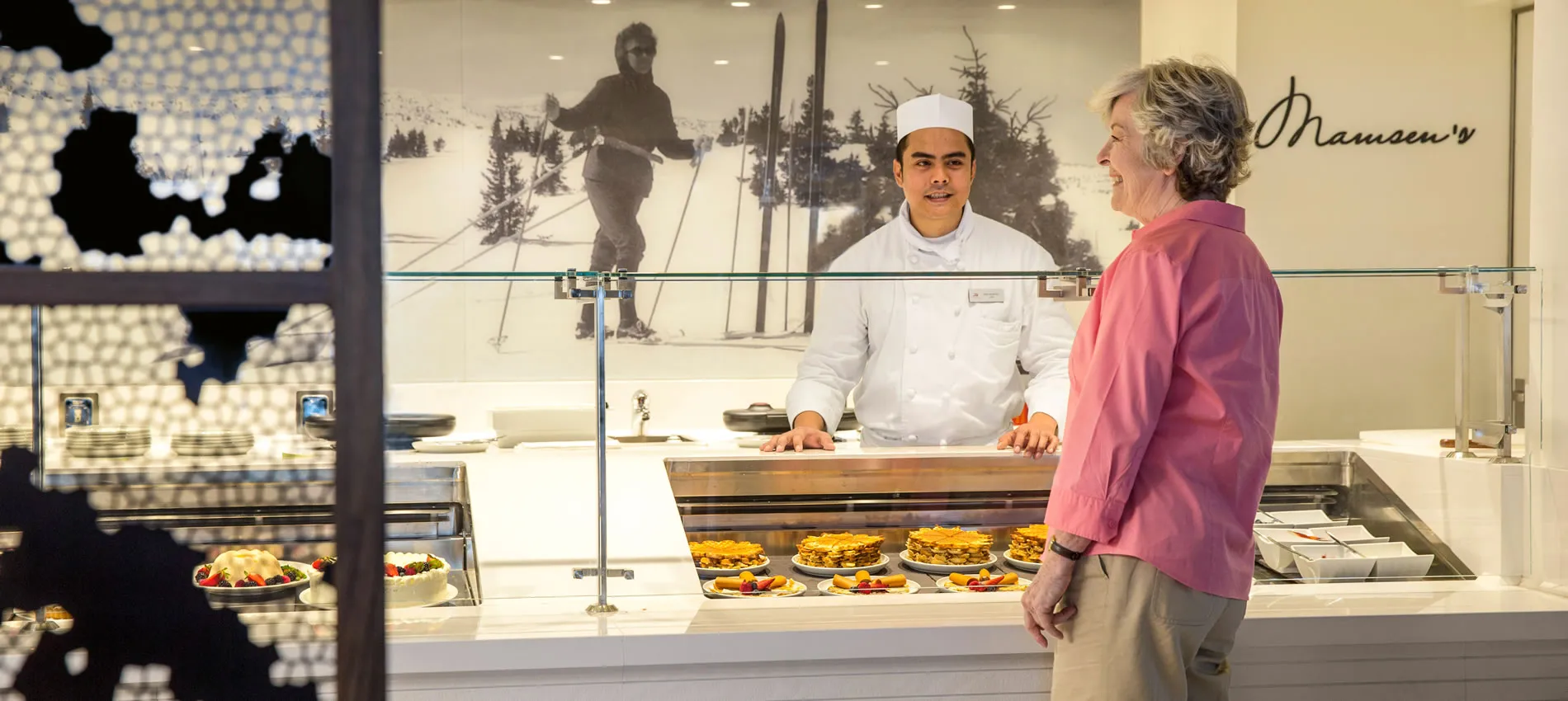Chef and customer at Maueen's cafe with vintage ski poster and fresh food