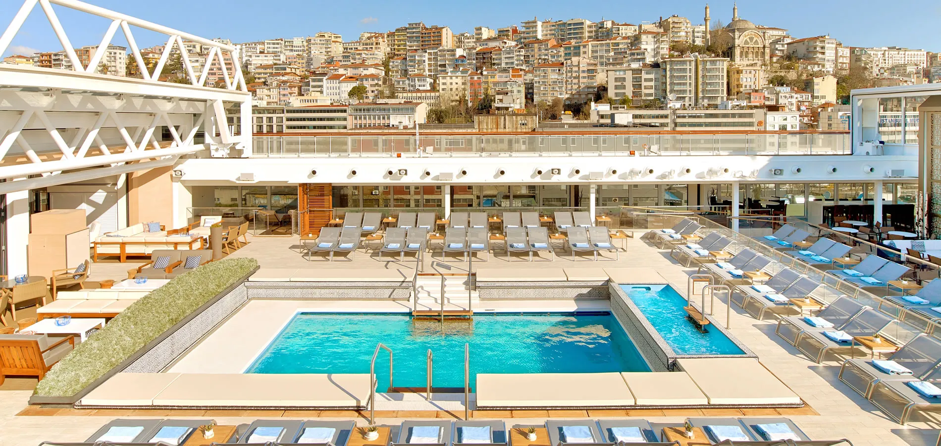 Modern rooftop swimming pool with city skyline in background