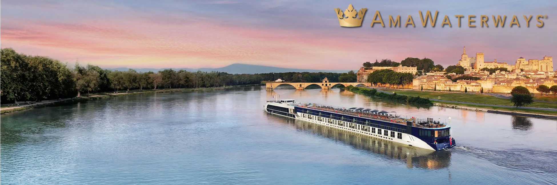 AmaWaterways river cruise ship sailing past historic Avignon bridge at sunset
