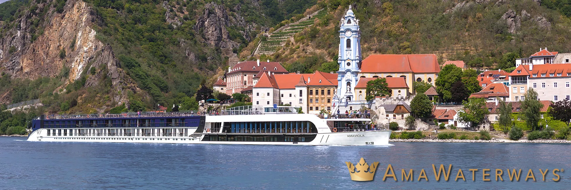 River cruise ship docked near historic European town with blue church tower