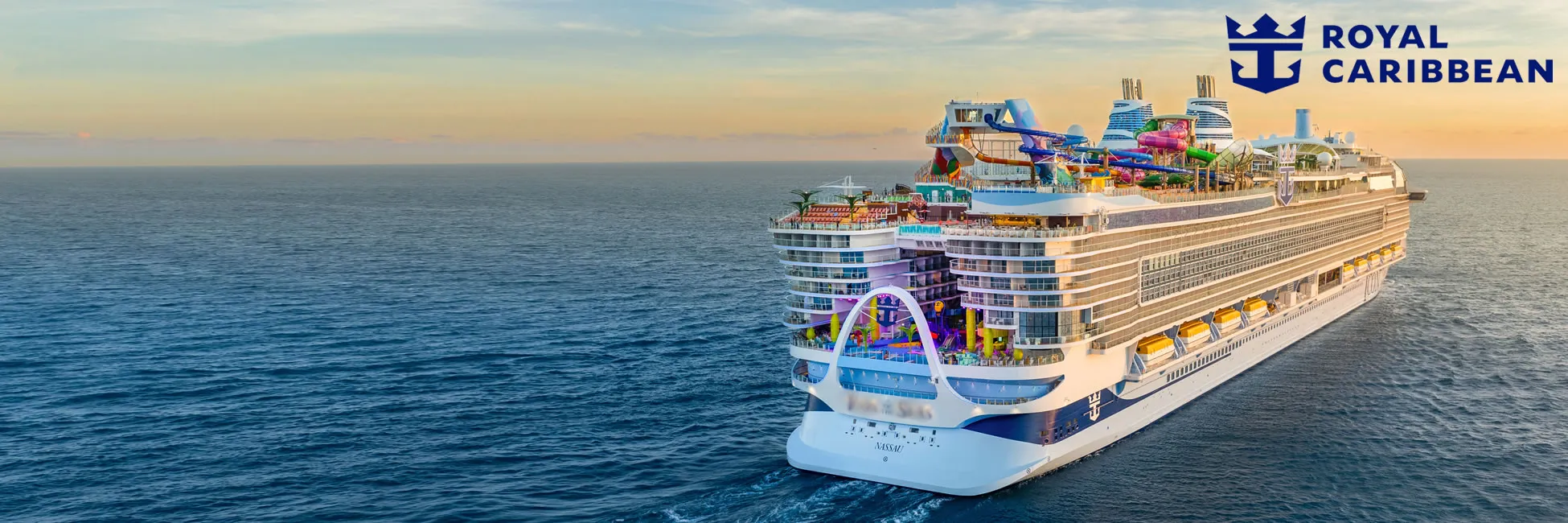 Royal Caribbean cruise ship with colorful water slides at sunset on open ocean