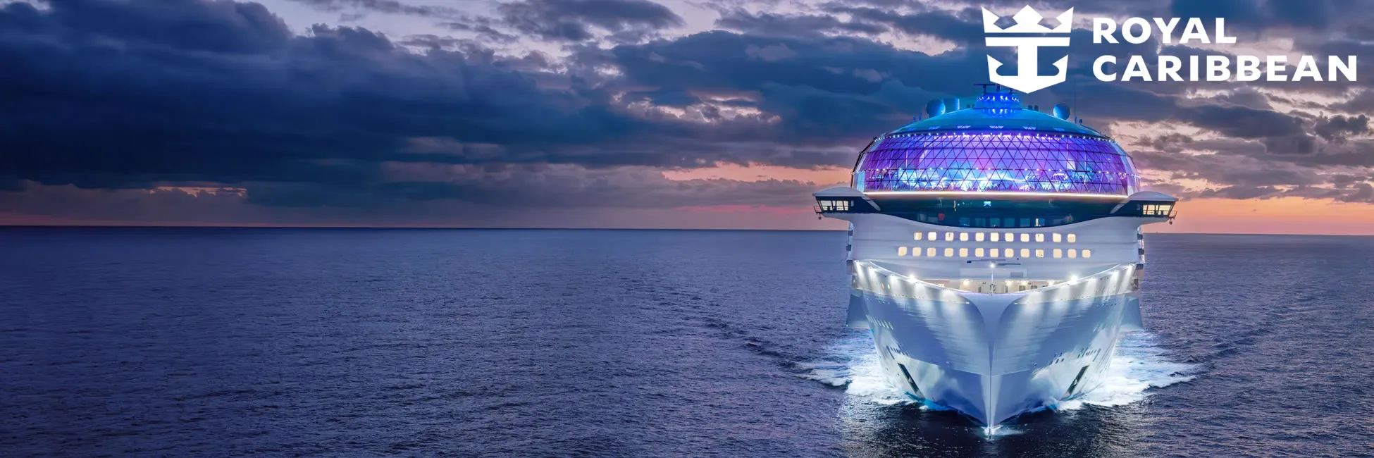 Royal Caribbean cruise ship with illuminated dome sailing at sunset