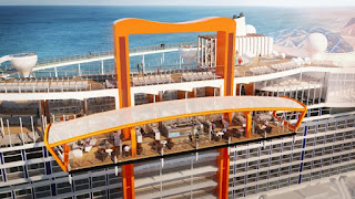 Orange frame lifts scenic railway car overlooking blue ocean coastline