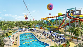 Colorful water park with slides, pools, and hot air balloon on sunny day
