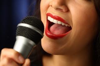 Close-up of red lips singing passionately into a black microphone