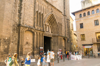 Gothic cathedral entrance with tourists in historic European city street