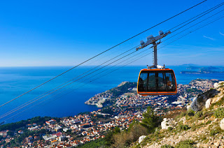 Cable car overlooking coastal city and blue Mediterranean sea