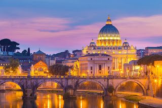 Vatican City's St. Peter's Basilica illuminated at twilight over Tiber River