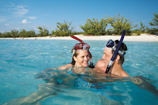 Two snorkelers in turquoise water enjoying tropical beach and ocean