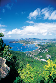 Scenic coastal landscape with blue bay, boats, and lush green vegetation