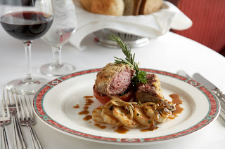 Gourmet medium-rare steak with rosemary, plated with sauce and garnish