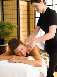 Massage therapist giving relaxing back massage in spa treatment room