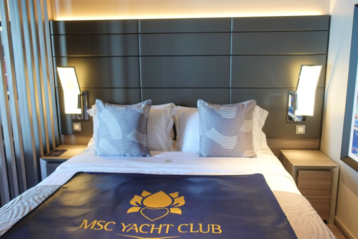 MSC Yacht Club luxury cruise ship cabin with blue and white bedding