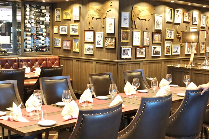 Elegant restaurant interior with leather chairs and gallery wall of artwork