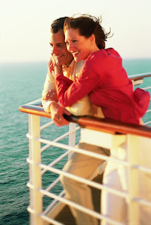 Two people enjoying ocean view from ship deck on sunny day