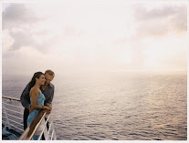 Couple embracing on a dock overlooking a calm, misty seascape at sunset