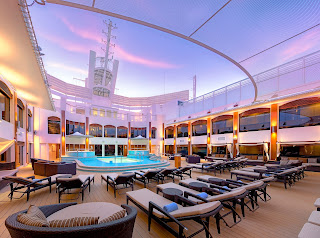 Luxurious cruise ship deck with pool, lounge chairs at sunset
