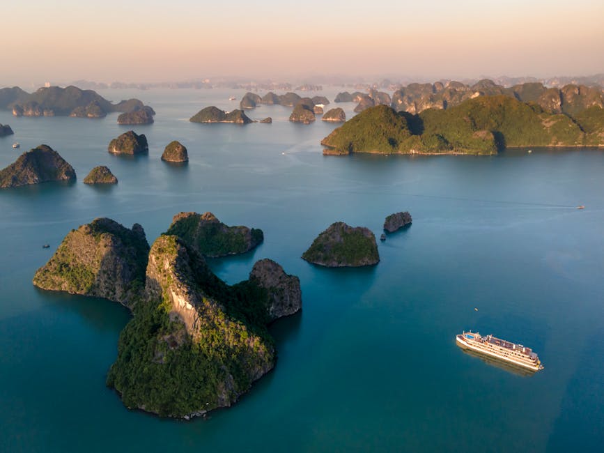 Stunning aerial view of Ha Long Bay's limestone karsts and cruise ship during sunrise.