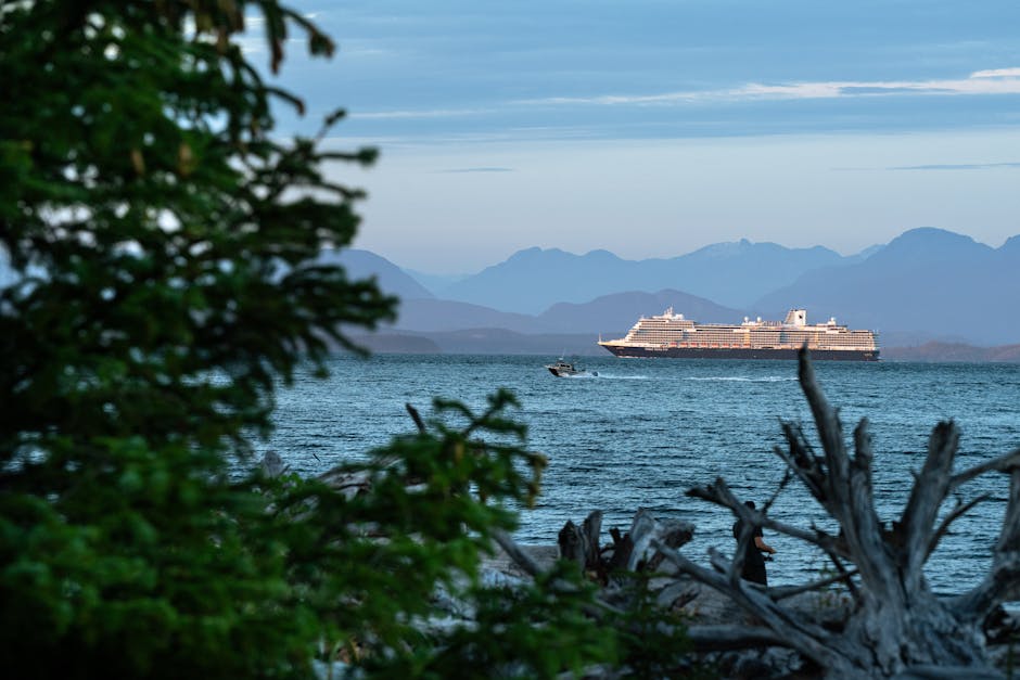 Serene scene of a cruise ship sailing along the coast of Campbell River, BC, framed by lush greenery.