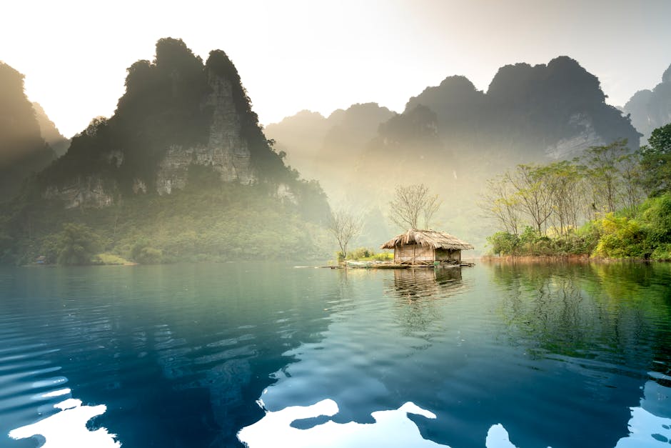 Peaceful scene of misty mountains and calm lake in Tuyên Quang, Vietnam, perfect for tranquil escapes.
