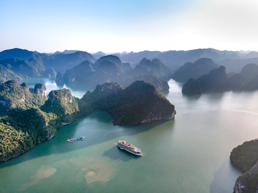 A stunning aerial view of a cruise ship sailing through the islands of Ha Long Bay.