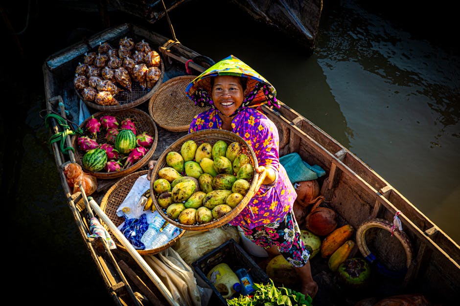 A joyful woman selling fresh fruits from her boat on a sunny day at a floating market.