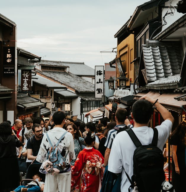 Crowded street scene in Kyoto with traditional architecture and people in kimonos.