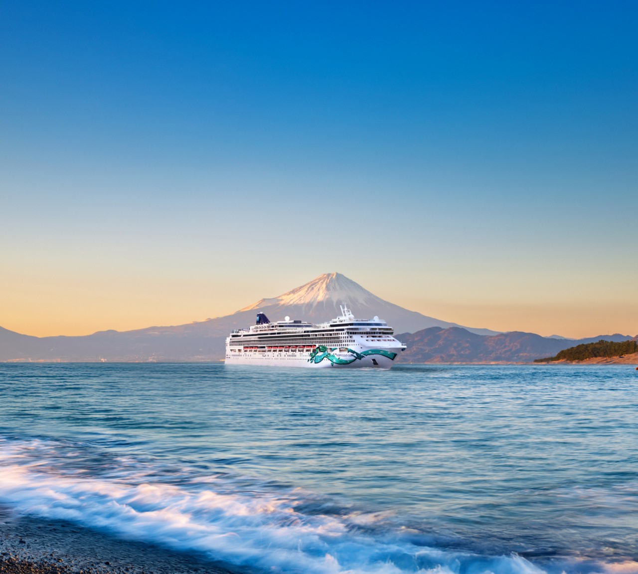 Norwegian Cruise Line ship in front of Japan's Mount Fuji