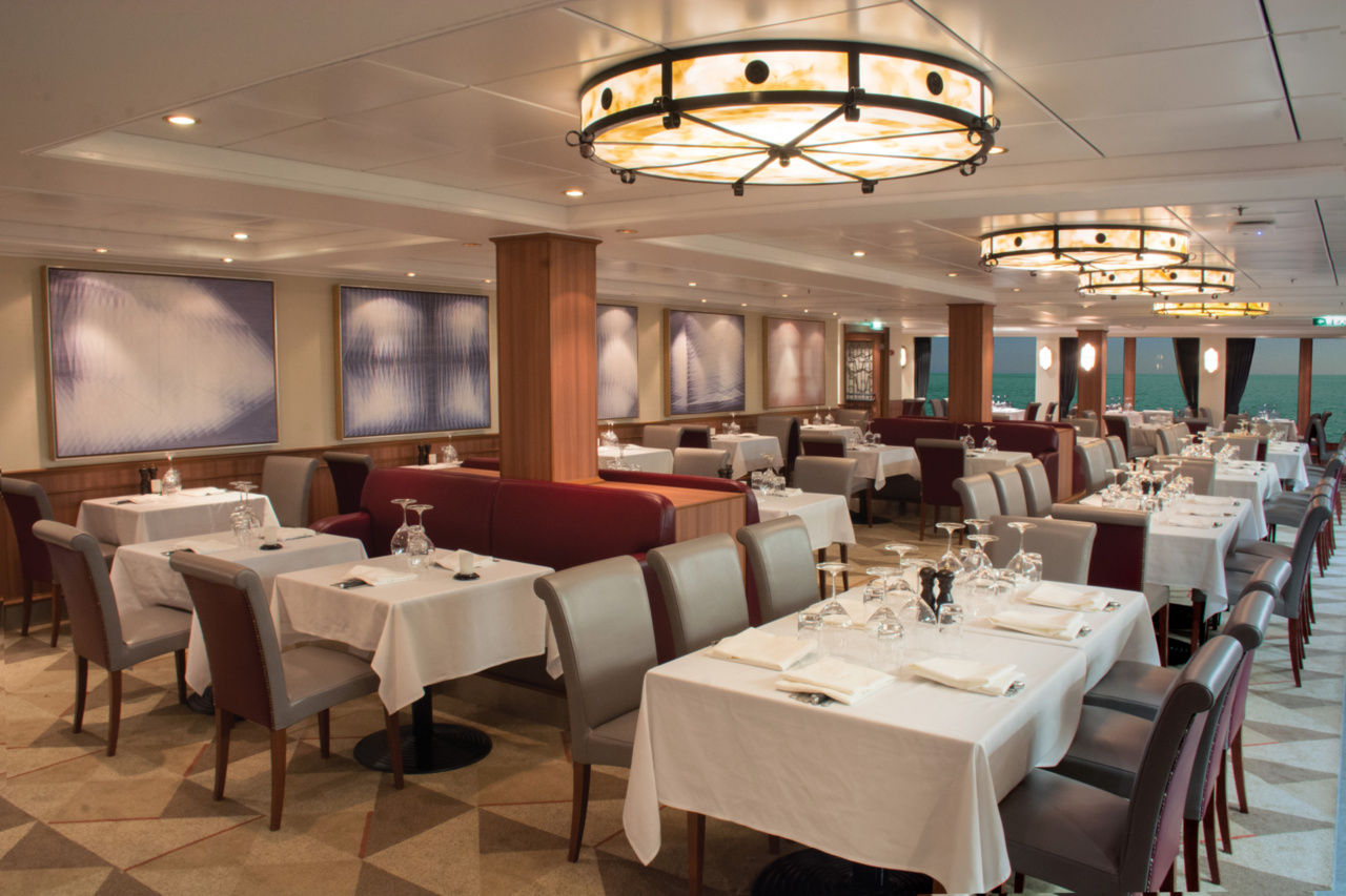 Cagney's Steakhouse specialty restaurant interior aboard Norwegian Cruise Line's Jewel with elegant table settings and warm ambient lighting.