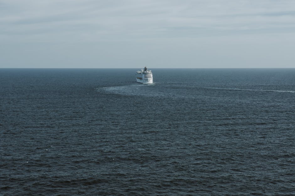 A lone cruise ship traversing the vast open Pacific Ocean near Australia under a clear sky, evoking the scale of a transpacific voyage from Auckland to Hawaii.