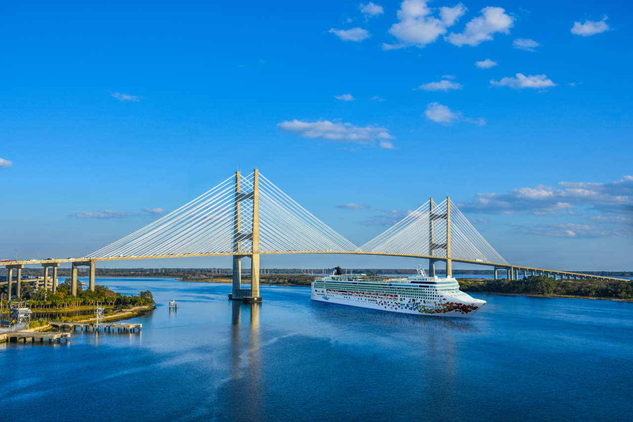 Norwegian Gem cruise ship transiting the St. Johns River at sunset near the Dames Point bridge in Jacksonville, Florida.