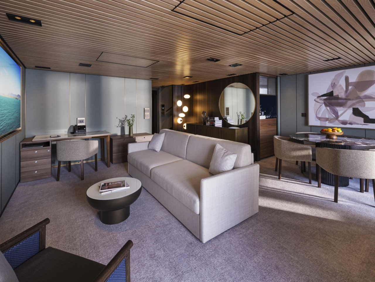 The living room of an NCL Haven Duplex Suite aboard Norwegian Luna, featuring comfortable seating, elegant furnishings, and ocean views through expansive windows.