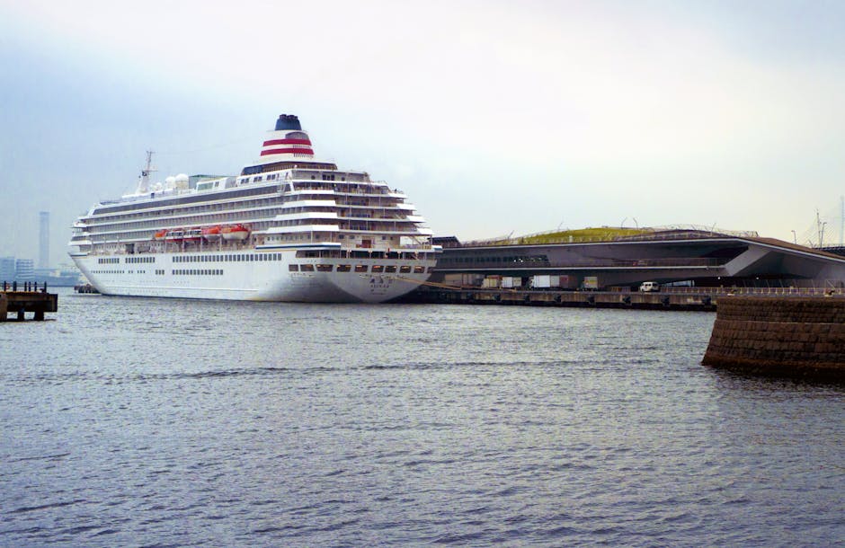 A large cruise ship docked at Yokohama port beside a modern terminal building, illustrating the embarkation experience at one of Japan's premier cruise ports.