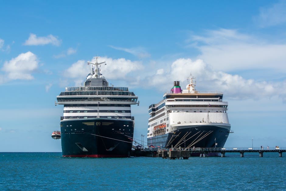 Two cruise ships of different scales docked side by side at a pier, illustrating how various cruise lines and vessel sizes compare when sharing the same port.