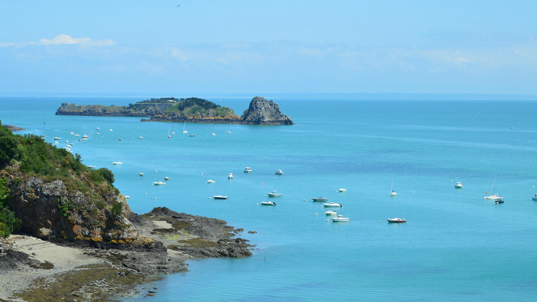 Coastal landscape of Cancale, Brittany, with traditional boats resting in the calm harbor waters — a quintessential stop along the Western France route from Bilbao.