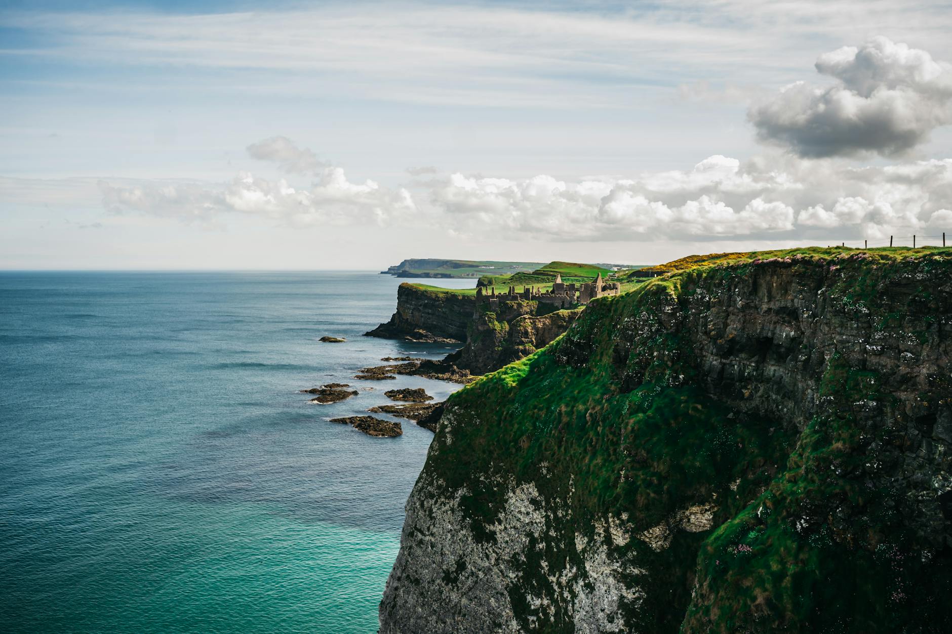 Rugged green cliffs draped in lush vegetation drop sharply into the Atlantic along the western Celtic coastline, illustrating the dramatic scenery cruise passengers encounter on British Isles itineraries.