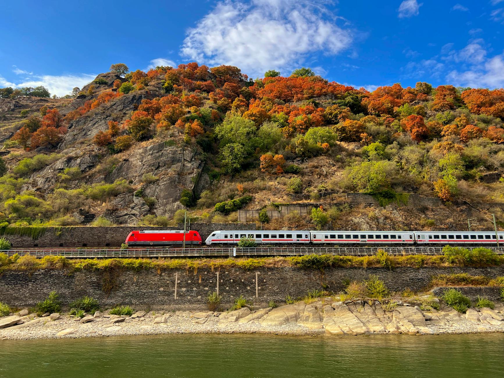 The Rhine River winding through Oberwesel's steep hillsides with autumn foliage, a classic Middle Rhine gorge landscape along the Basel-to-Amsterdam cruise route.