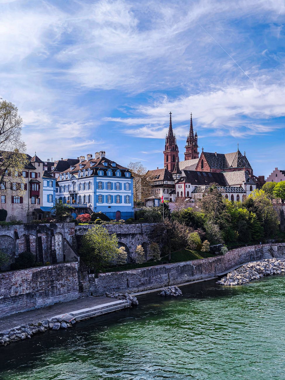 Picturesque Basel scene with historic cathedral and riverside view.