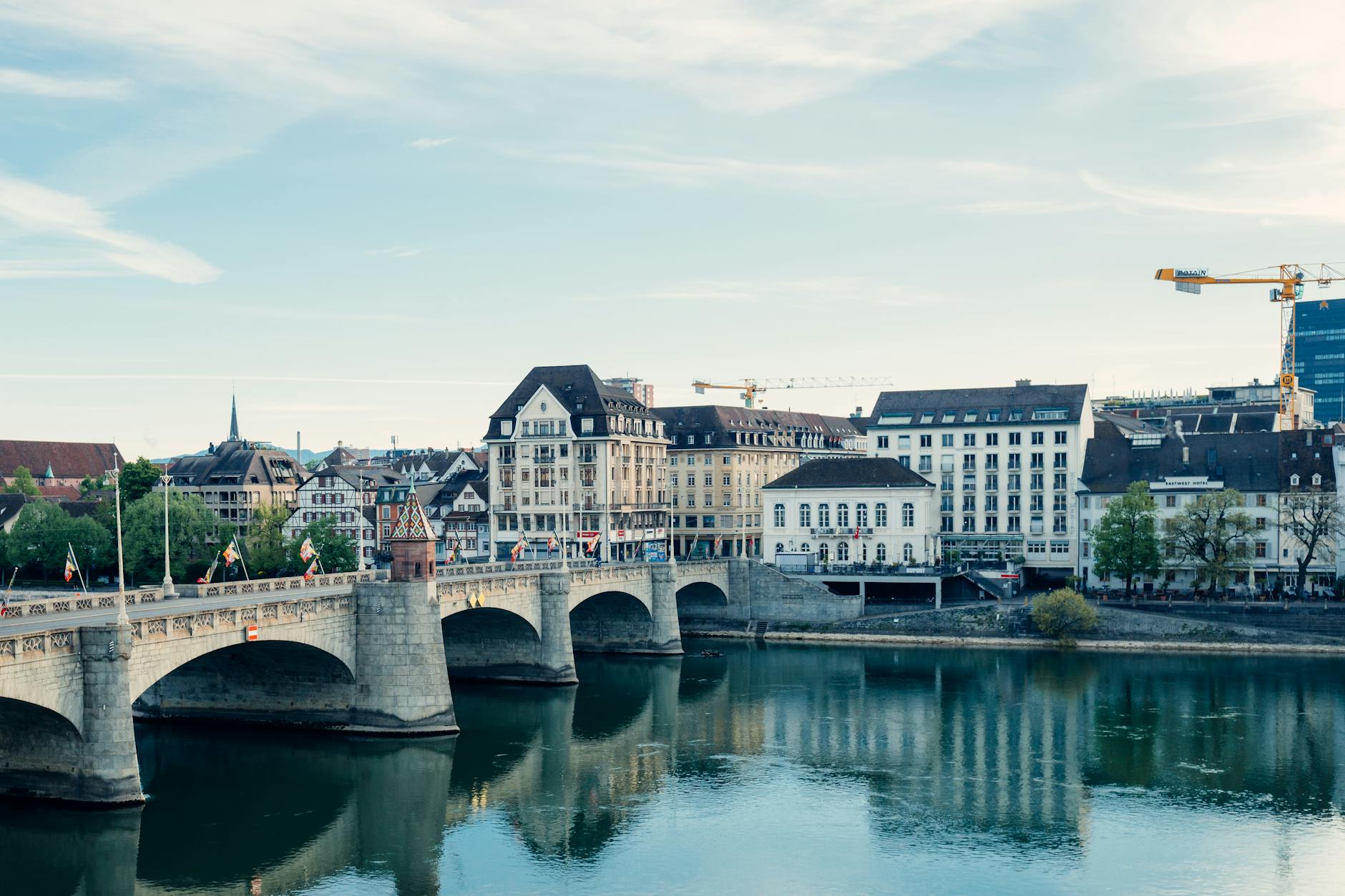 Scenic view of Basel city along the Rhine River showcasing architectural beauty and reflections.