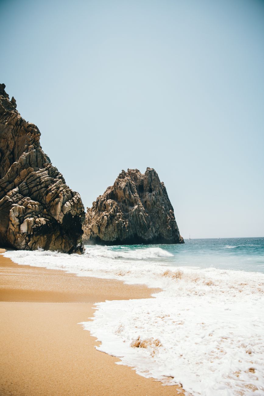 Explore the scenic beauty of Cabo San Lucas beach with striking rock formations and golden sand.