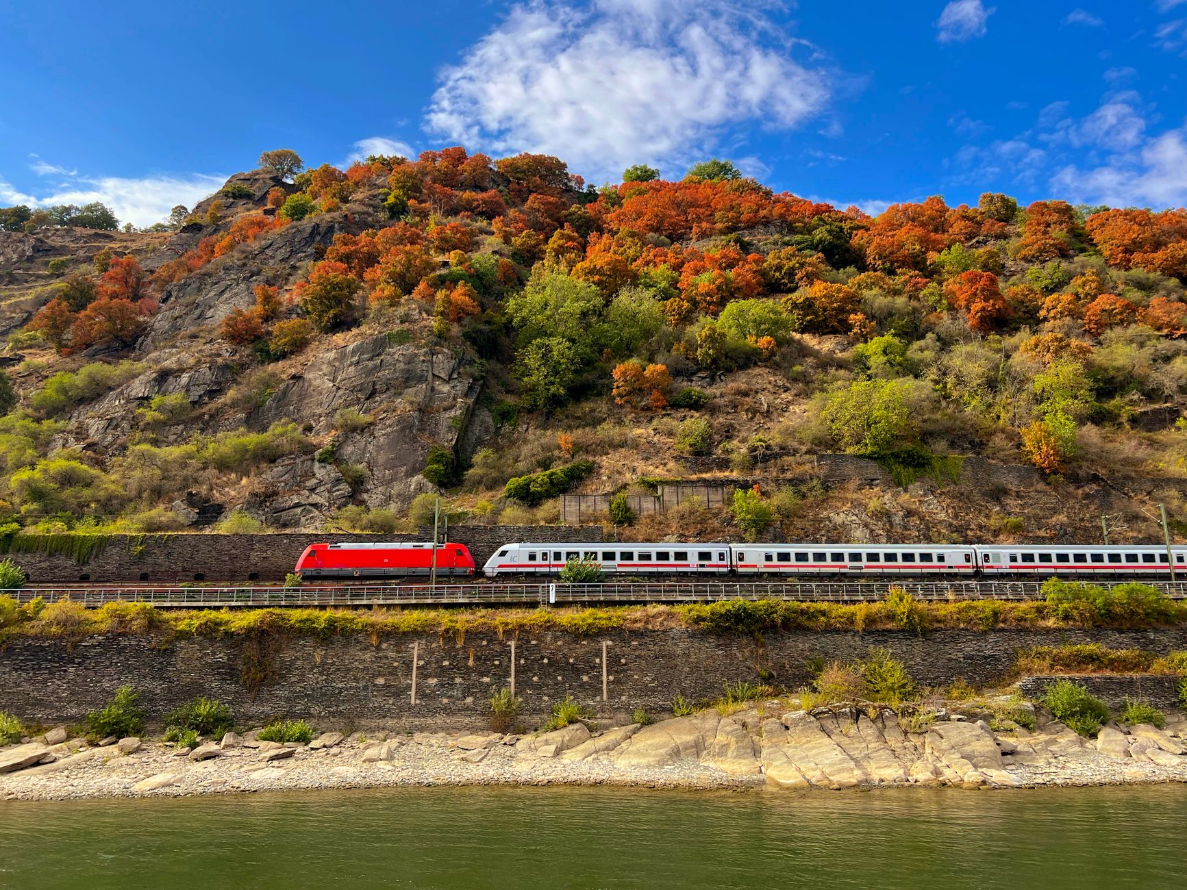 The Rhine River winding through Oberwesel's steep hillsides with autumn foliage, a classic Middle Rhine gorge landscape along the Basel-to-Amsterdam cruise route.