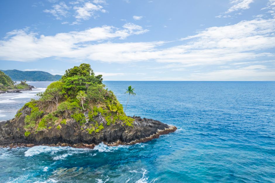 Turquoise waters and lush tropical greenery at Alega Beach in American Samoa, a classic South Pacific port of call on the Auckland-to-Hawaii cruise route