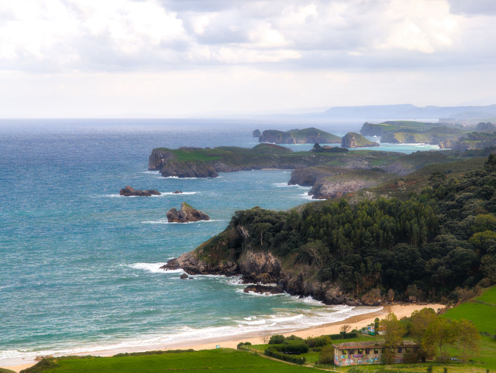 Dramatic cliffs and rugged coastline of Asturias, Spain, overlooking the vast Atlantic Ocean — the waters cruise ships traverse during a Bay of Biscay and Atlantic crossing.