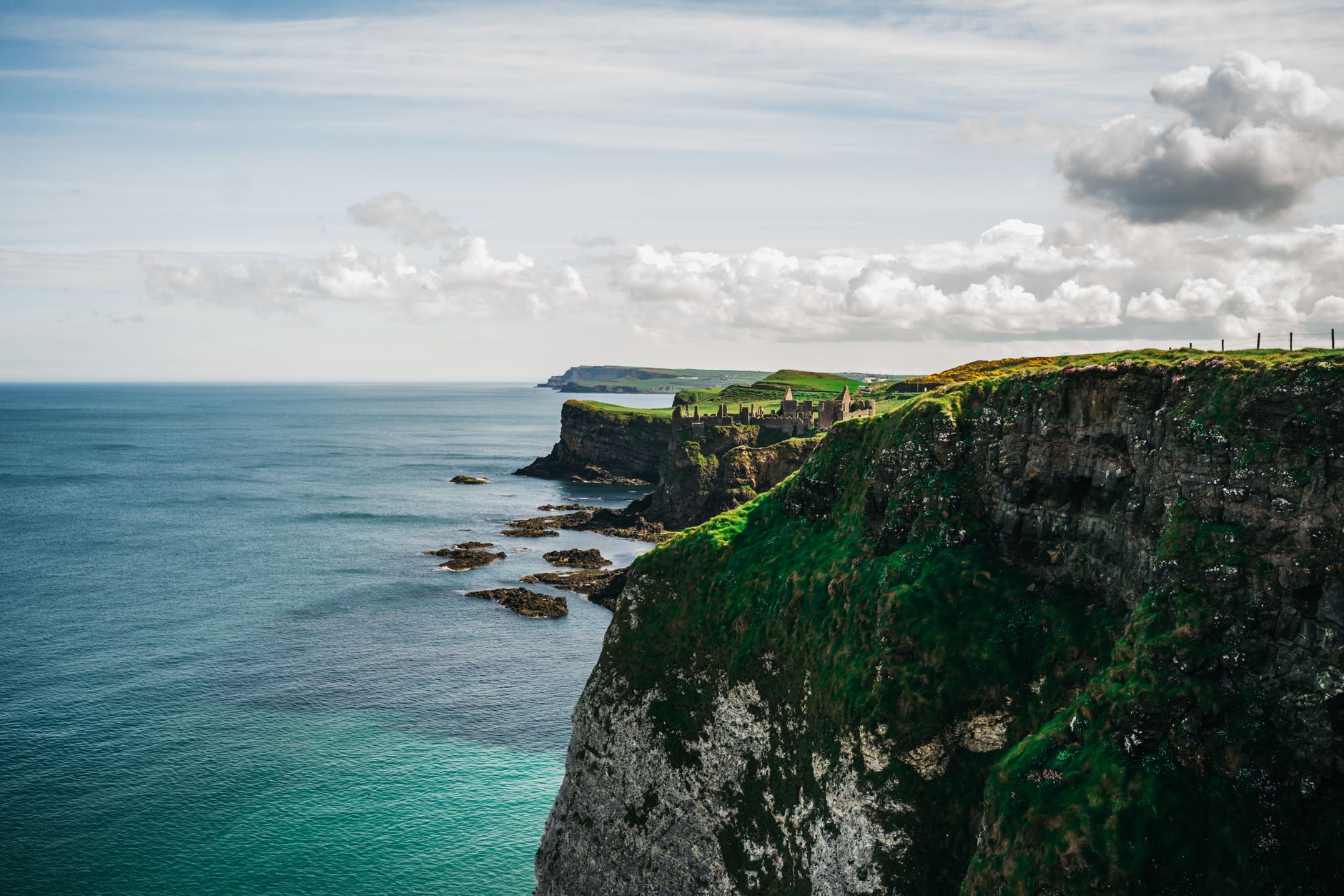 Rugged green cliffs draped in lush vegetation drop sharply into the Atlantic along the western Celtic coastline, illustrating the dramatic scenery cruise passengers encounter on British Isles itineraries.