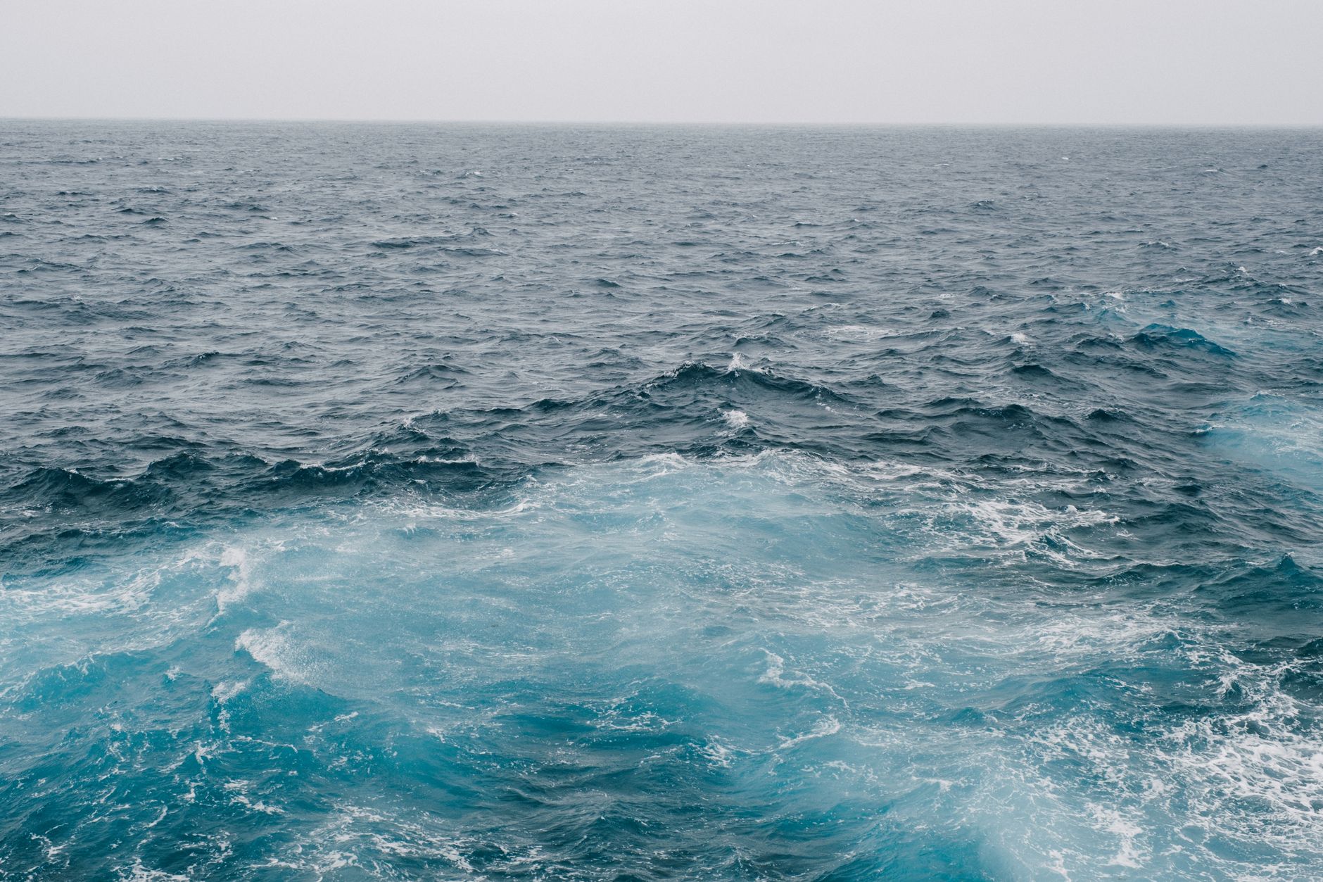 Vast and serene Atlantic Ocean stretching to the horizon with gentle waves under open sky, evoking the boundless expanse of a transatlantic crossing.